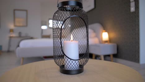 An-exquisite-hotel-bedroom-featuring-a-large-white-bed-and-a-burning-white-candle