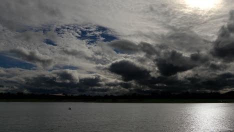 time lapse of a dramatic sky at dusk, with normal speed for the lake