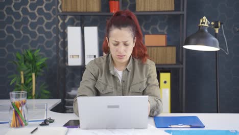 mujer de negocios estresada usando una computadora portátil.