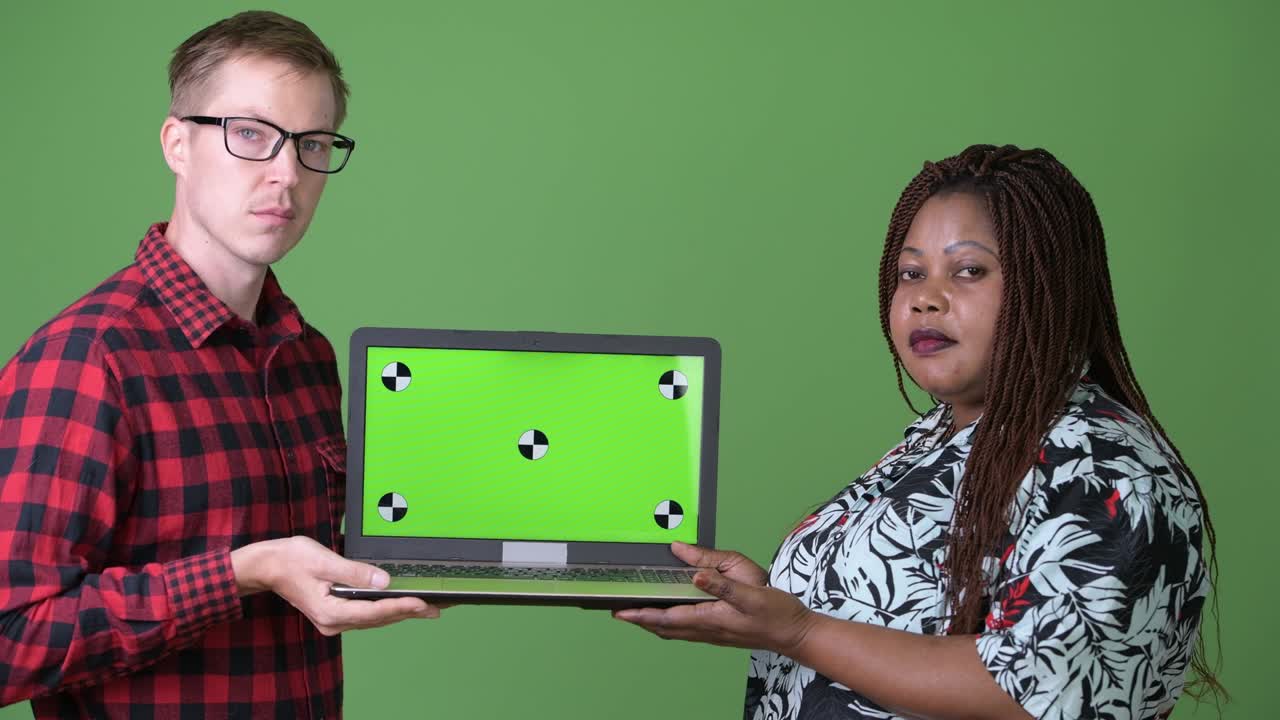 mujer africana con sobrepeso y un joven escandinavo juntos contra un fondo verde