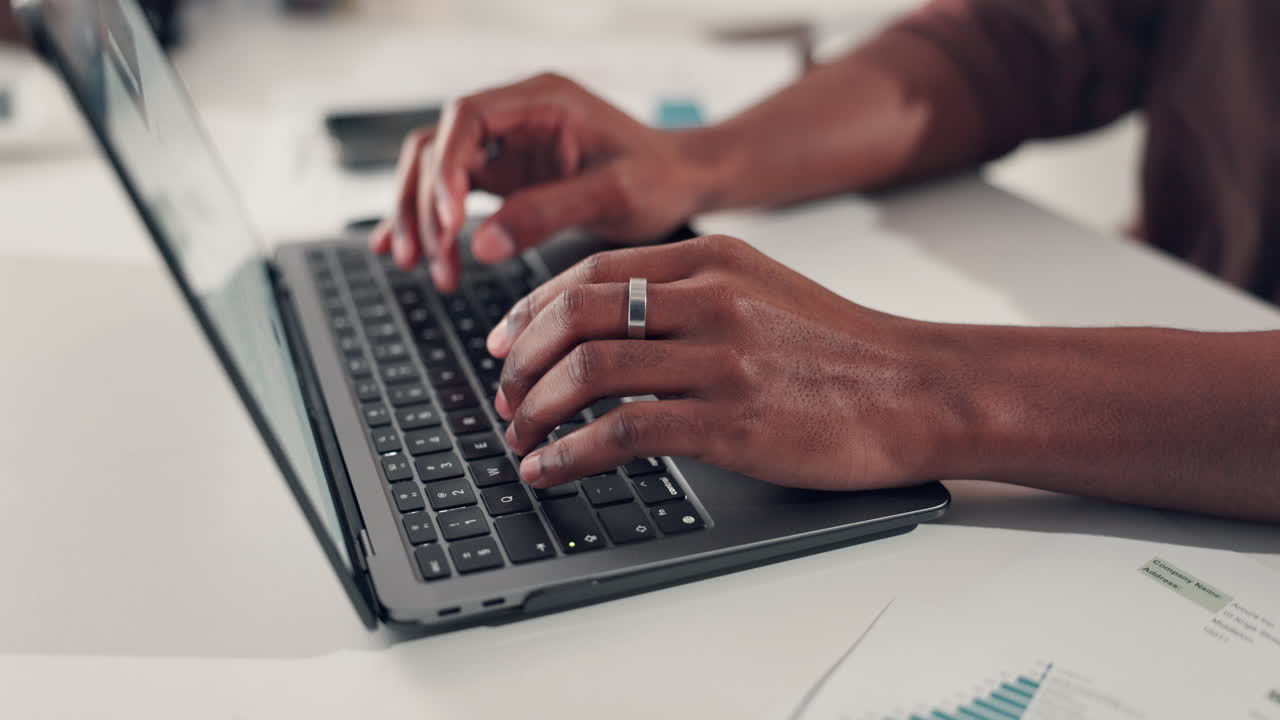 Hands typing on a laptop keyboard at work