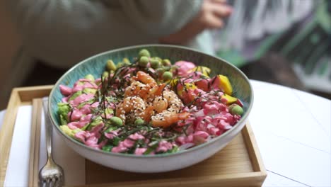 Panning-close-up-of-delicious-poke-bowl-in-restaurant