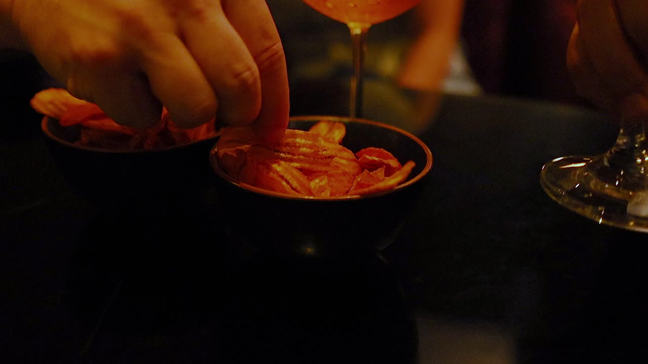 manos alcanzando para bocadillos con cóctel cerca