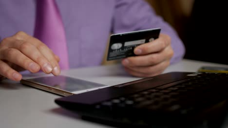 a businessman in a purple shirt and tie is making a payment to internet banking. shopping online with credit card on smartphone.