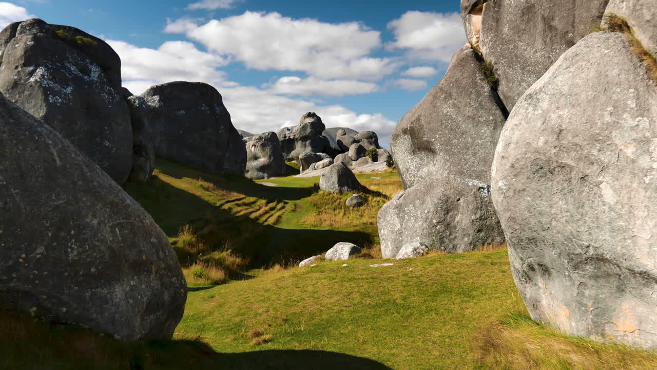 dolly vibrante tiro hacia adelante entre las rocas en la hierba en la colina del castillo durante el verano