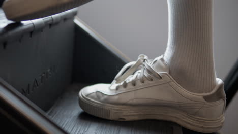 man's foots stepping up or climbing on stepmill stair climbing machine in gym - closeup