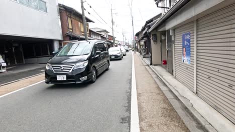 cars driving down a narrow traditional street