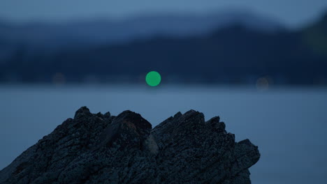 rock with blurred flashing green light behind