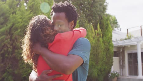 happy biracial couple hugging each other after proposal in garden