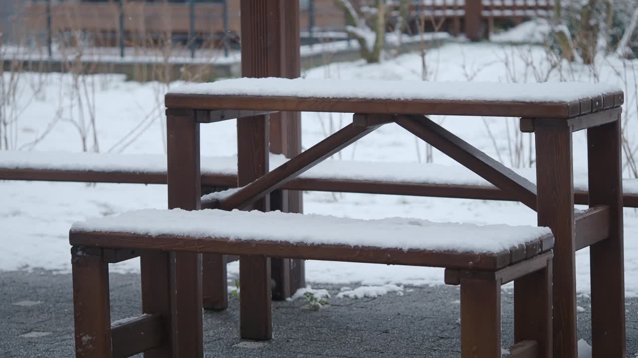Wooden table and benches covered in snow