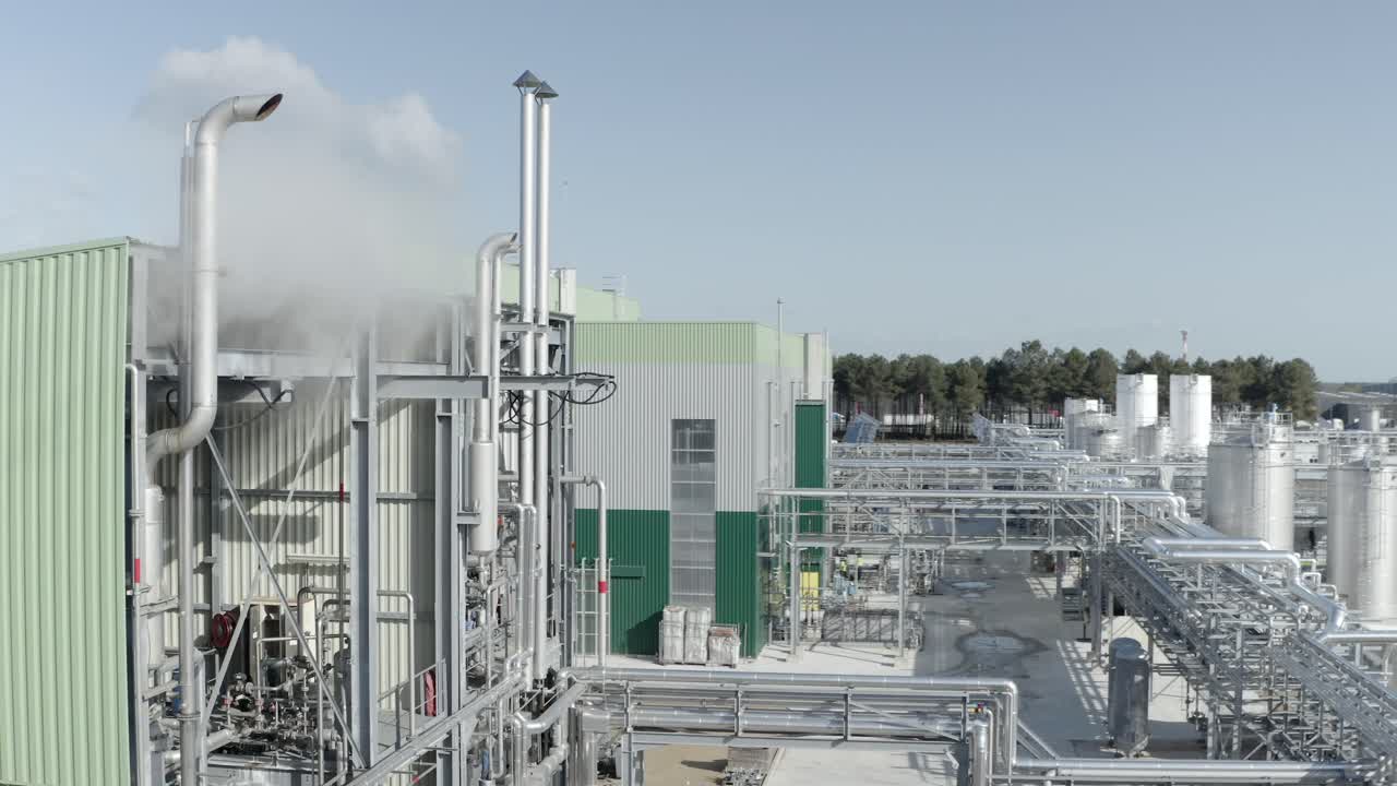 Aerial view of industrial building, revealing pipes, steam vents, and complex machinery within factory site, Castets, France