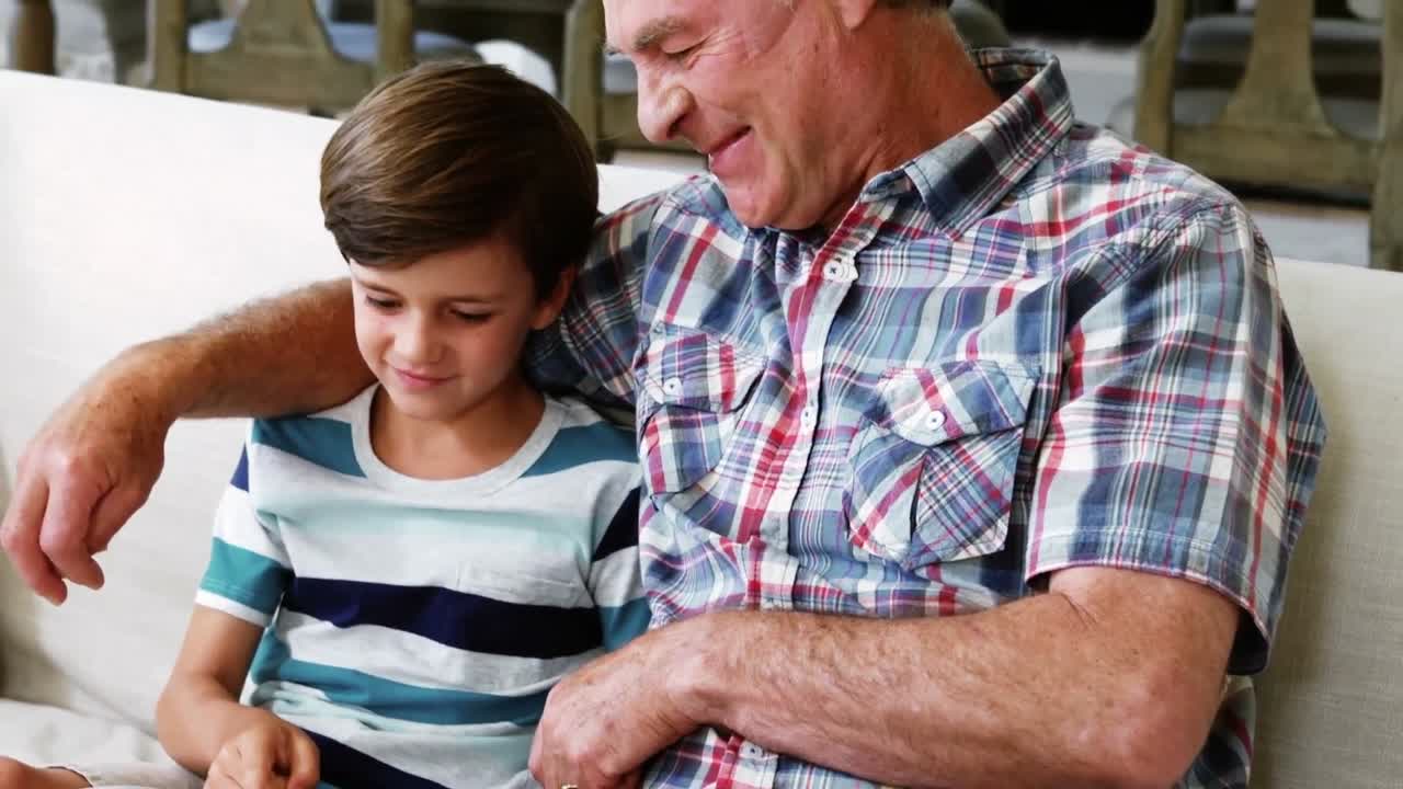 abuelo interactuando con su nieto en el sofá