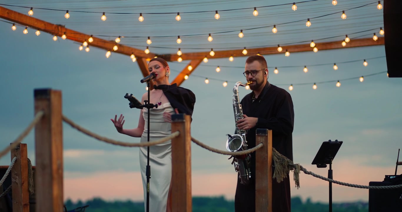 Kvindelig sanger og saxofonist optræder live på udendørs scene