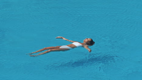woman swimming on a blue water pool