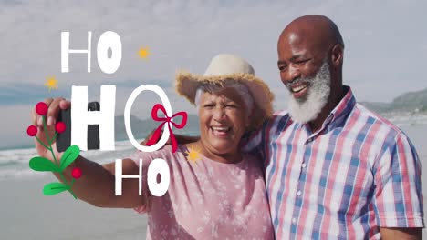 Animation-of-christmas-greetings-text-over-senior-diverse-couple-on-beach