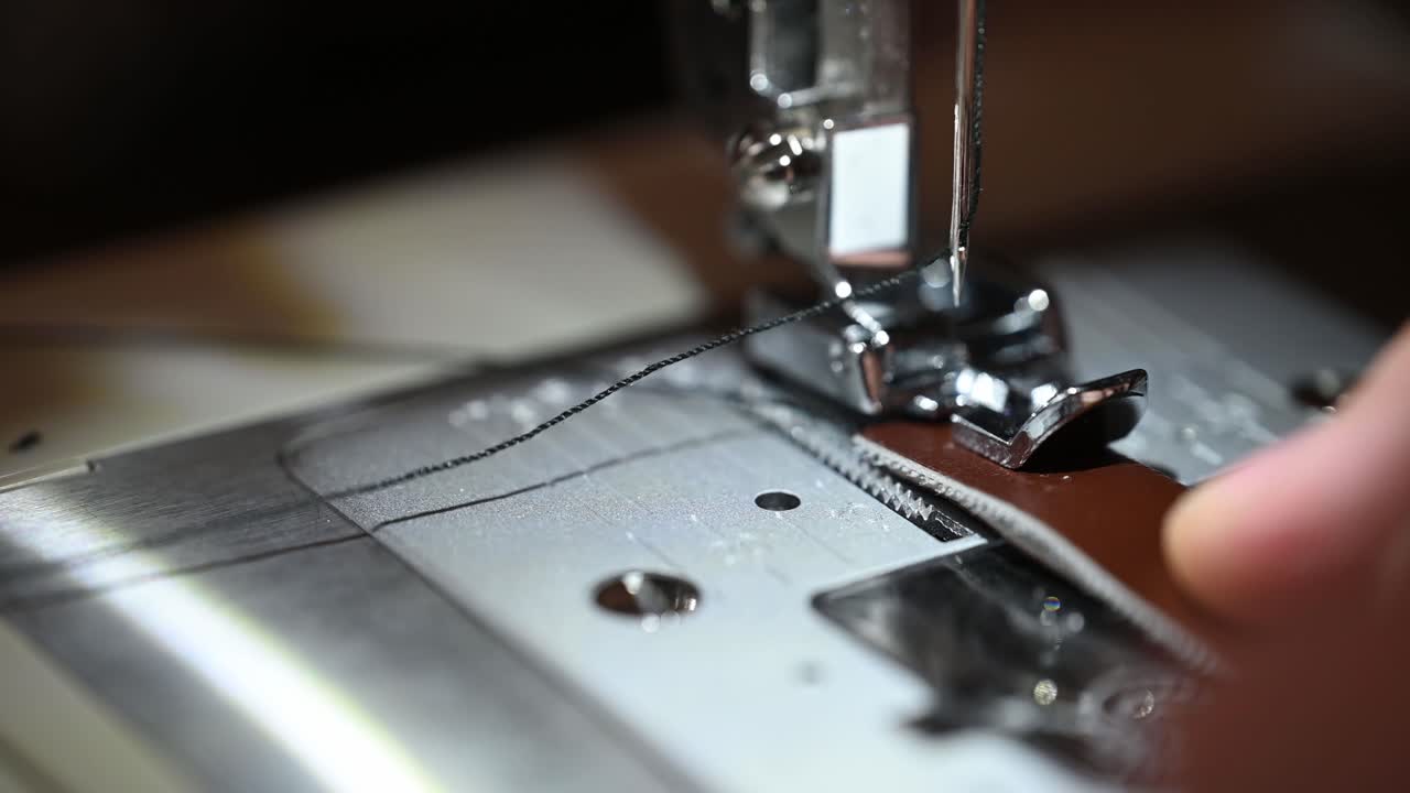 мужская рука, шитье, крупный план иглы, двигающейся вверх и вниз