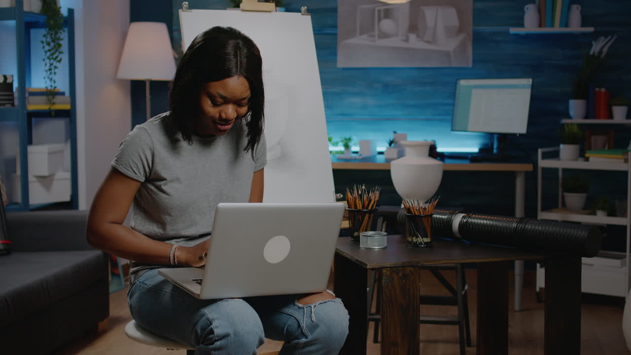 Young artist of african american ethnicity using laptop