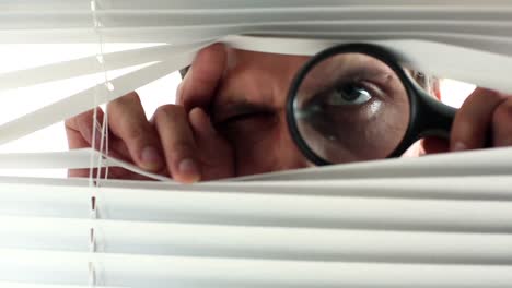 curious businessman peering out of his office