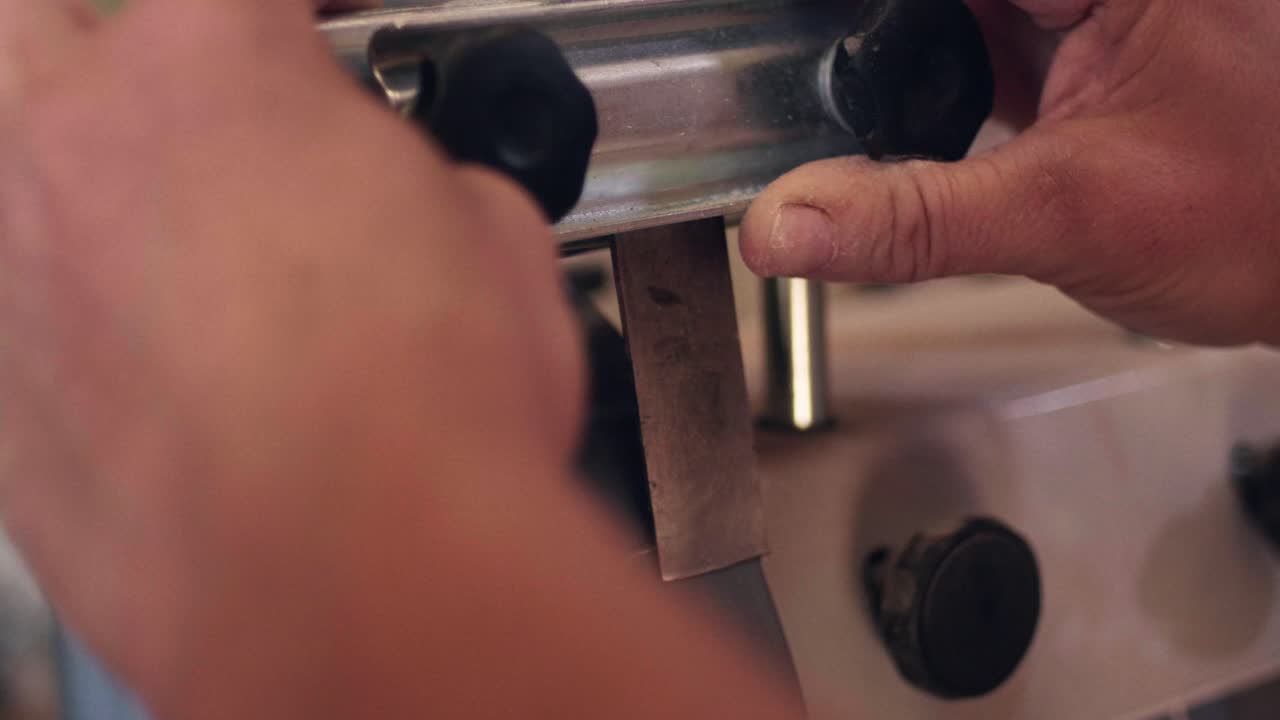Skilled artisan hands meticulously scraping wood surface to achieve smoothness. Detail shot of the woodworking process. Slow motion
