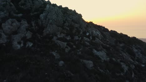 Aerial-reveal-shot,-4K-footage,-sunrise-gets-revealed-from-behind-a-mountain