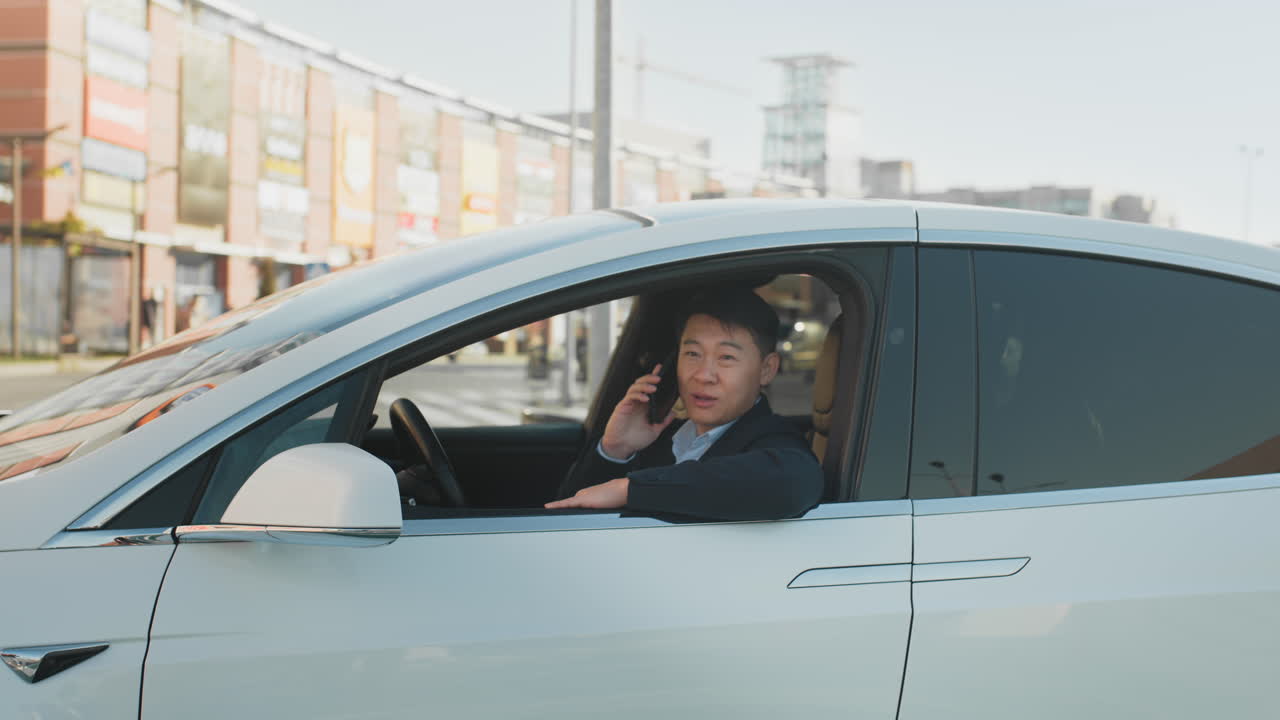 도시 에서 전기 자동차 를 운전 하는 동안 전화 로 이야기 하는 사람