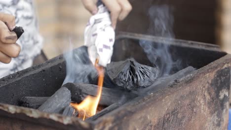 Anzünden-Eines-Feuers-In-Einem-Grillplatz-Mit-Einem-Feuerzeug