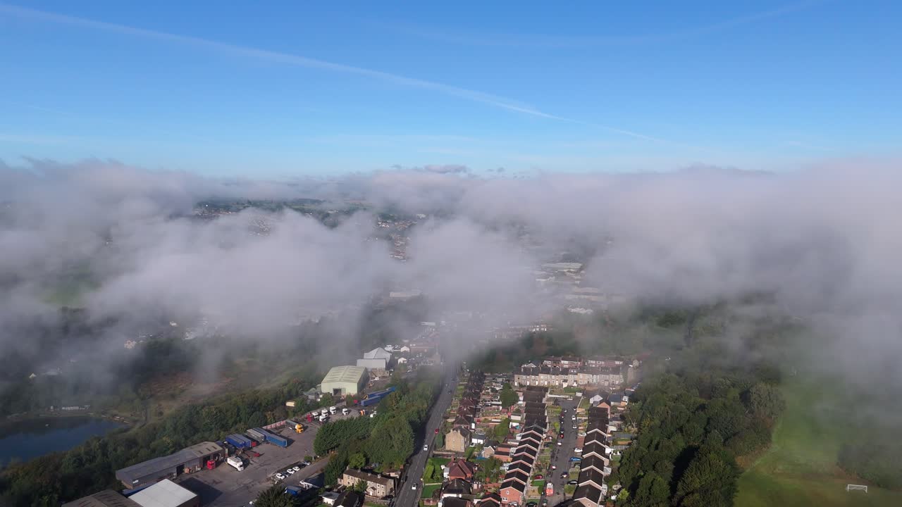 Suburban landscape covered by thick morning mist and fog, Small town of Dewsbury and Heckmondwike. Cold winter Yorkshire morning. Cityscape with homes rooftops and busy roads. Winter scene