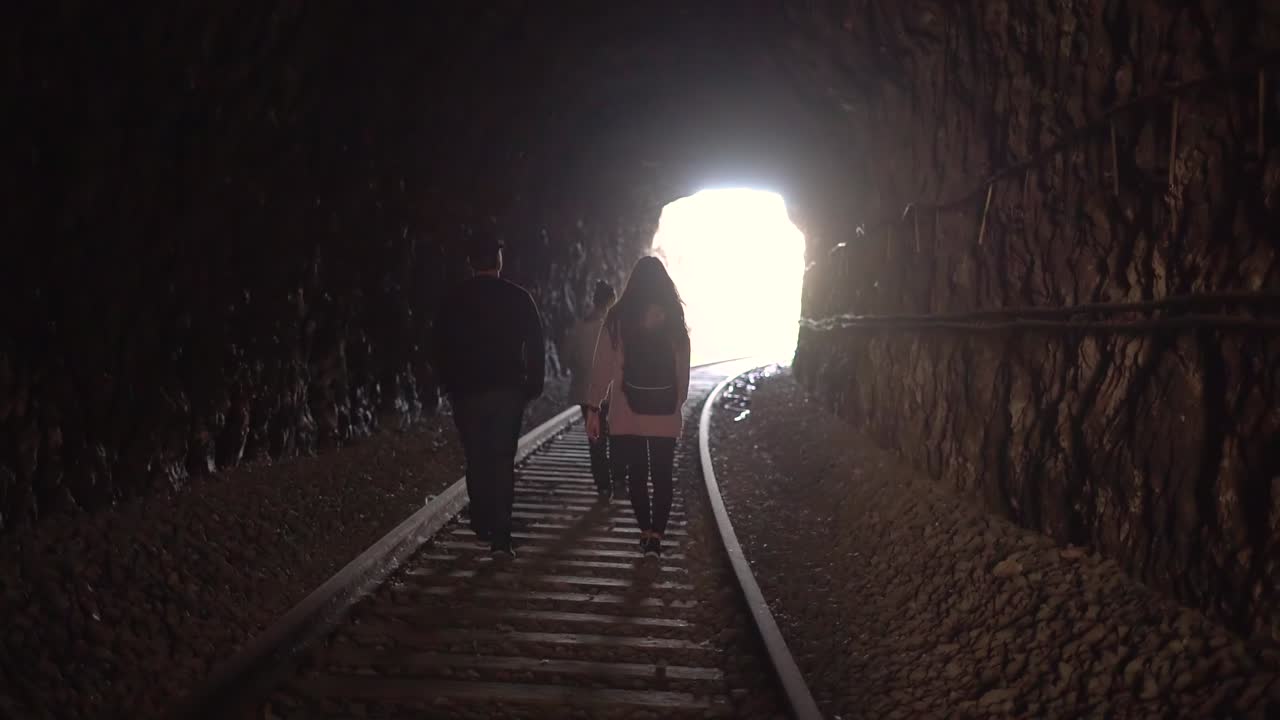People walking on abandoned railway. Forgotten paths hiker group of backpacker friends. Hiking adventure in nature.