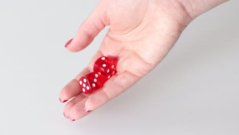 hand rolling red dice on white background