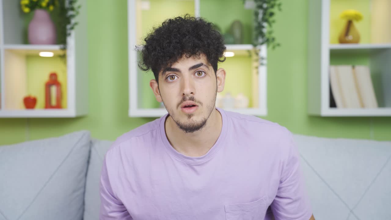 Young man looking at camera with admiration. He is surprised by the news.