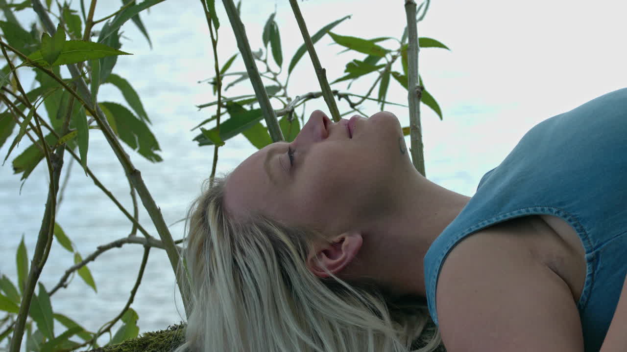 la mujer esta acostada en el arbol