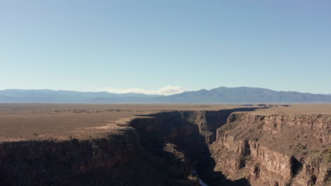 aerial of rio grande gorge in with wildfire burning in distant mountains