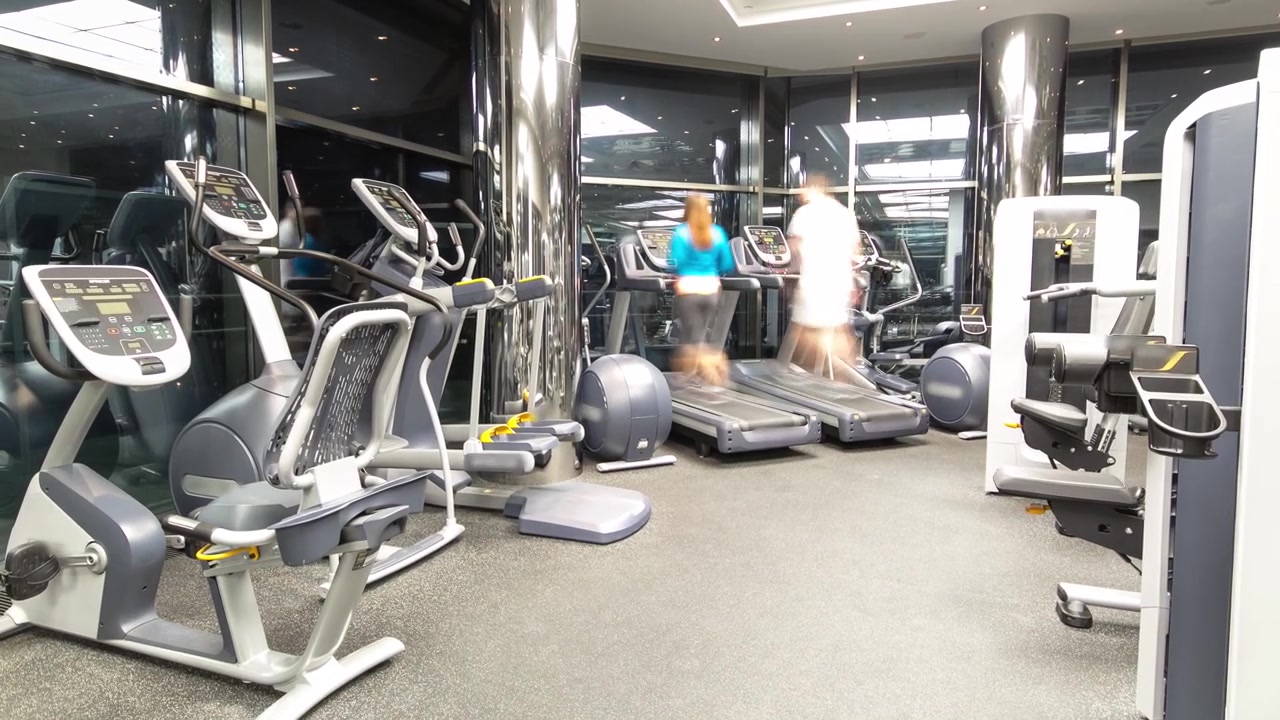 Interior of new modern gym with equipment timelapse hyperlapse. People work on training apparatus