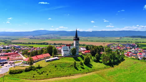 church on the hill in the picturesque rural area. drone footage in the countryside of slovakia. tatra mountains at backdrop
