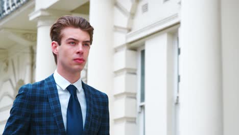 stylish young man carrying coffee walking on city street