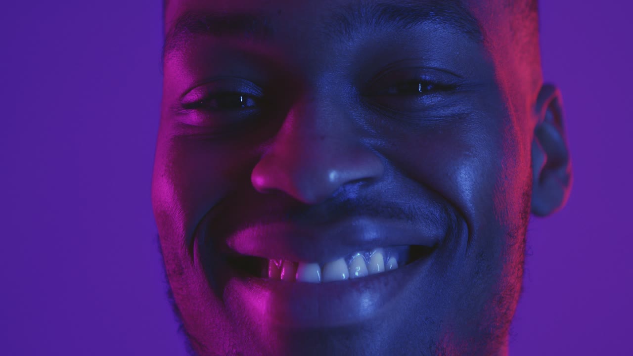 retrato en primer plano de un hombre sonriente con una brillante iluminación de neón