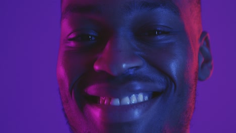 close-up portrait of a smiling man with vibrant neon lighting