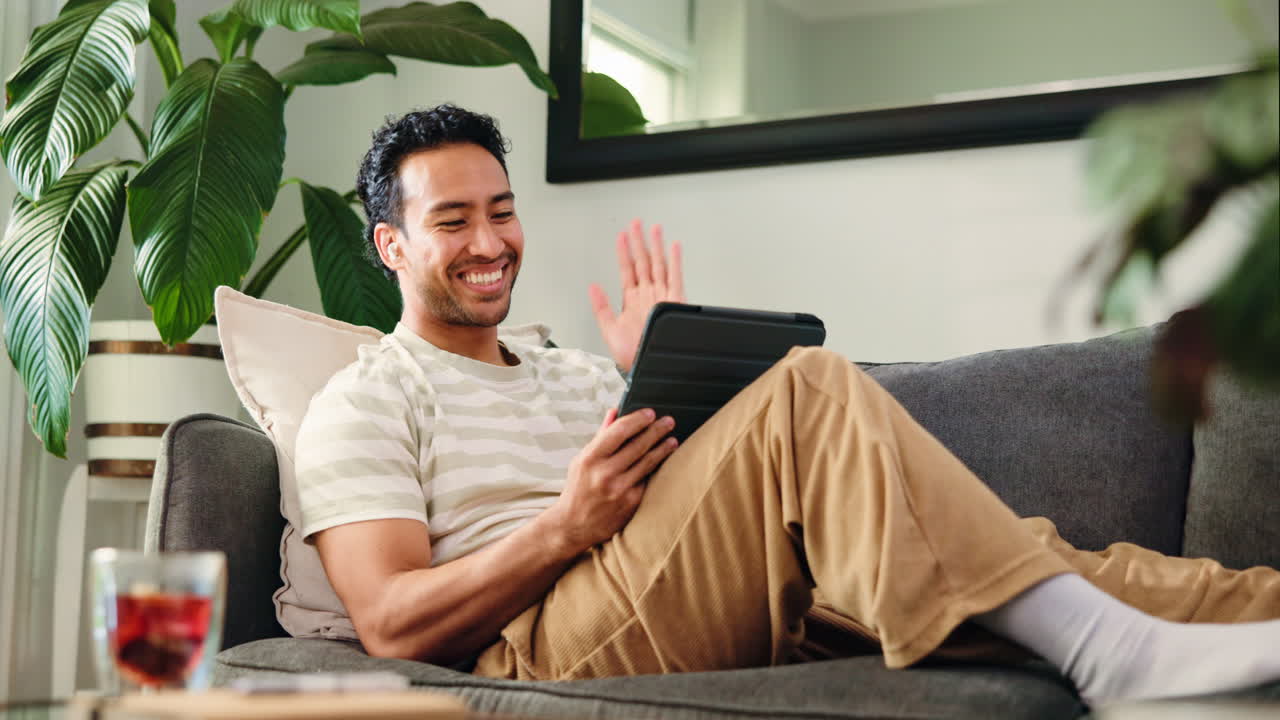 Happy Man Waving and Smiling During Video Call on Tablet at Home