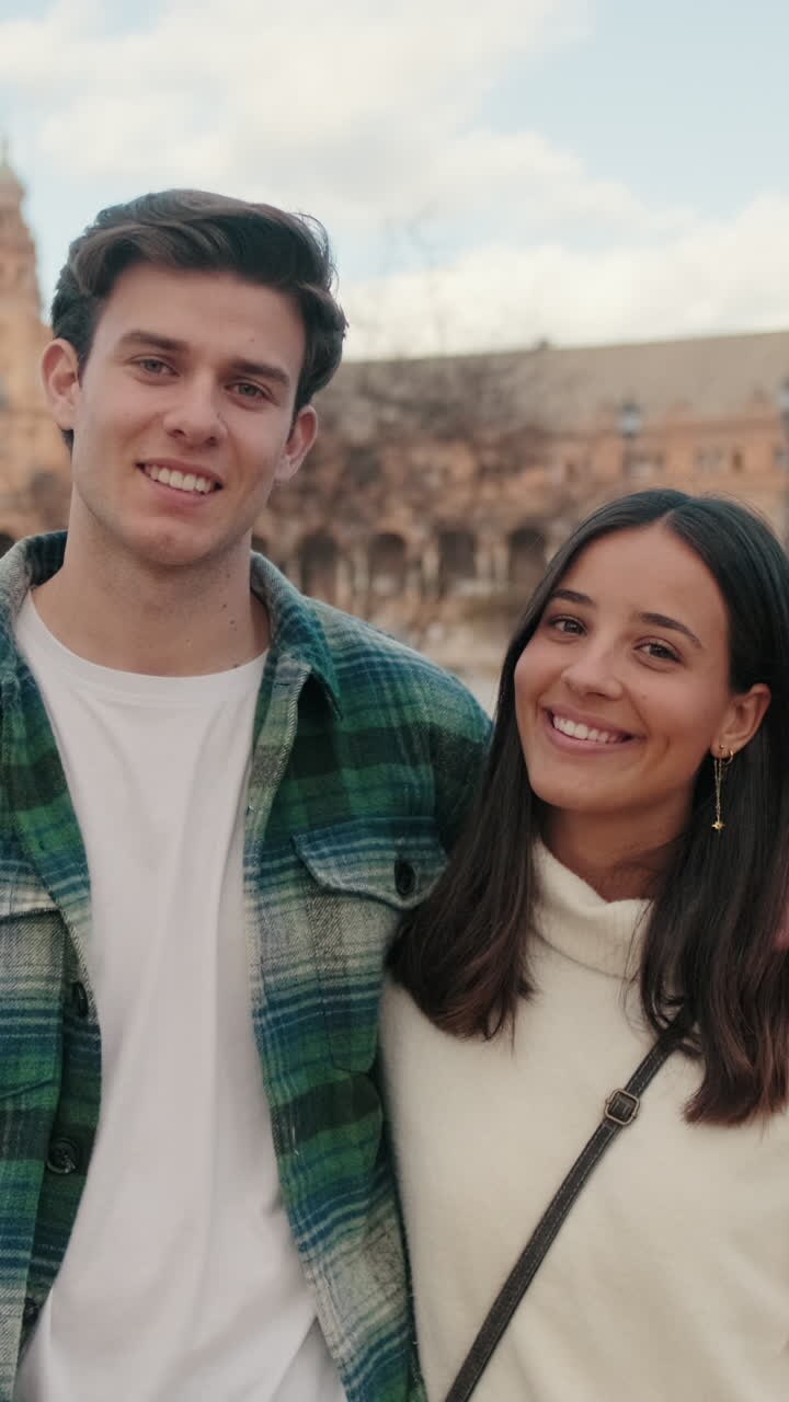 Happy young partners man and woman hugging and kissing while standing on bridge