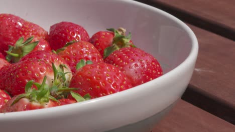 Low-Angle-View-of-a-Bowl-of-Strawberries-Outside-in-Bright-Sunlight