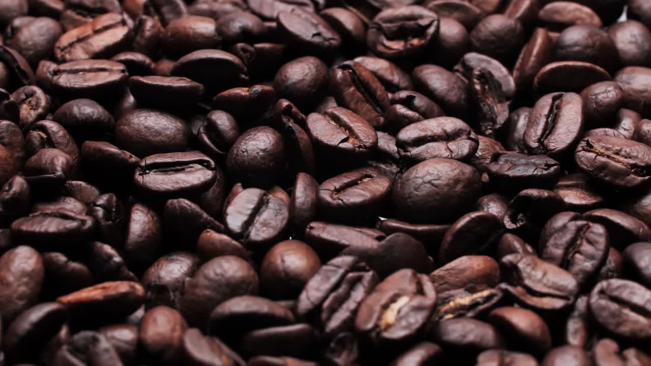 frijoles de café tostados en el fondo. bucle de video. primer plano