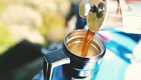 french press pours coffee or tea into a thermos and finishes on the top of a mountain shot in 4k super slow motion