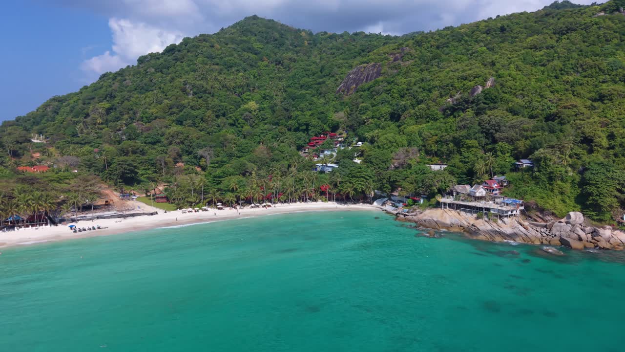Elevated drone footage capturing calm emerald sea along Haad Rin coastline in Thailand