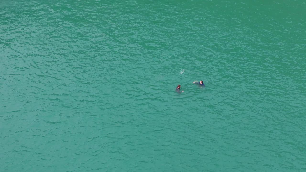 People Swimming On Turquoise Greeny Blue Waters Of Abereiddi's Blue Lagoon In Pembrokeshire, Wales United Kingdom. Aerial Shot