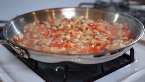 mezcla vegetariana chisporroteando en una sartén sobre una estufa - cámara lenta
