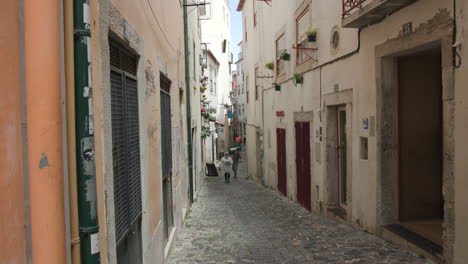 an empty narrow street in lisbon portugal during the pandemic