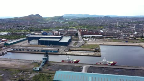 A-Pan-Across-the-Ship-Yard-at-Leith-Docks-with-Ships,-Trucks-and-Warehouses-|-Edinburgh,-Scotland-|-4K-at-30-fps