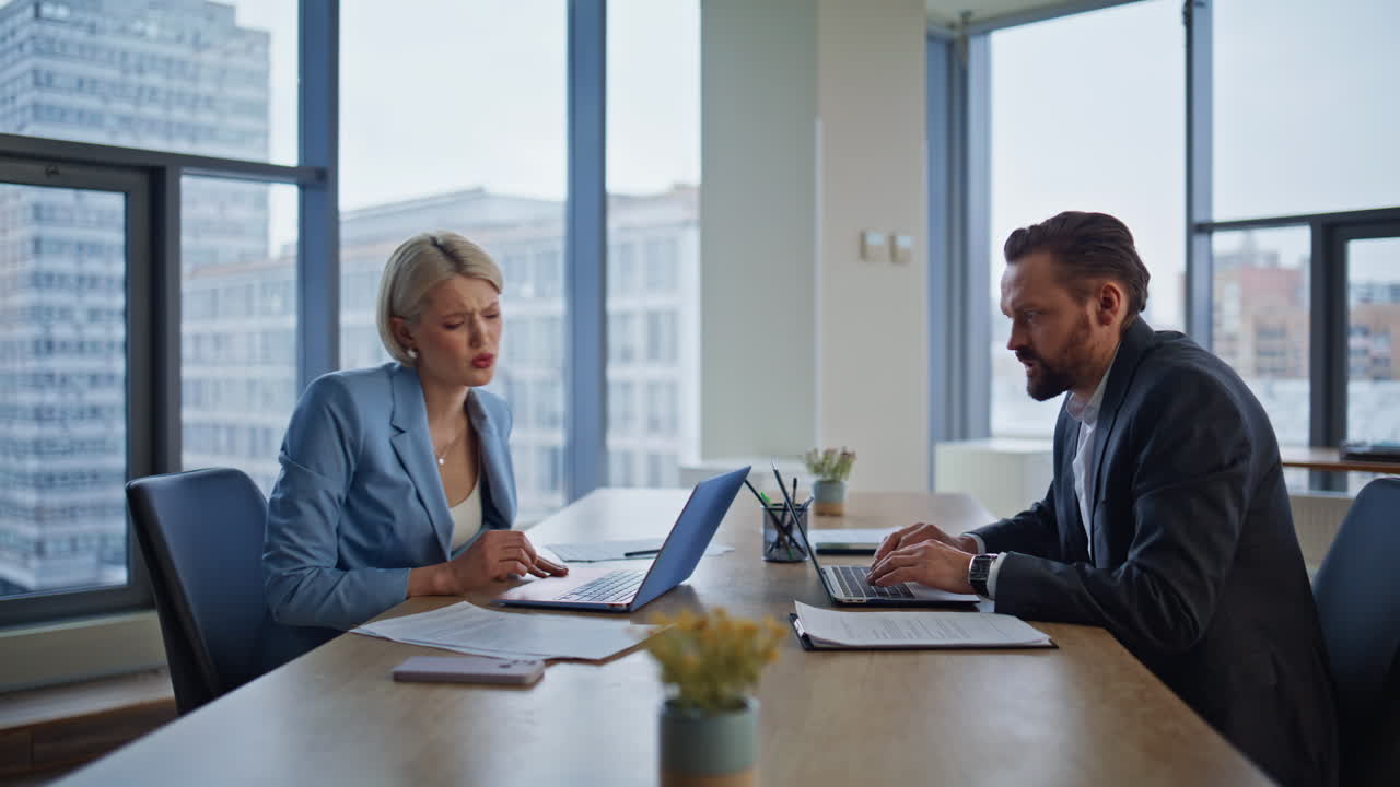 Gestresste professionals die een vergissing maken op het werk, bezorgd probleem in panorama-kantoor