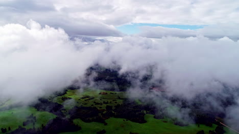 vuelo aéreo a través de densas nubes y mostrando un valle verde en el campo
