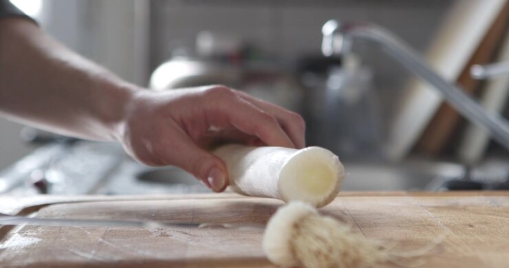 Girl Chopping Leeks on a Wooden Chopping Board in Daylight Kitchen, Close Up on Hands